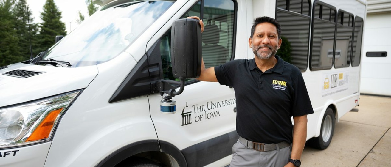 Omar Ahmad in front of the automated shuttle bus