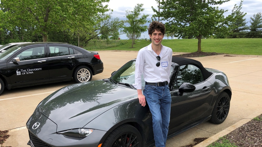 Thomas outside of NADS leaning against his Mazda Miata