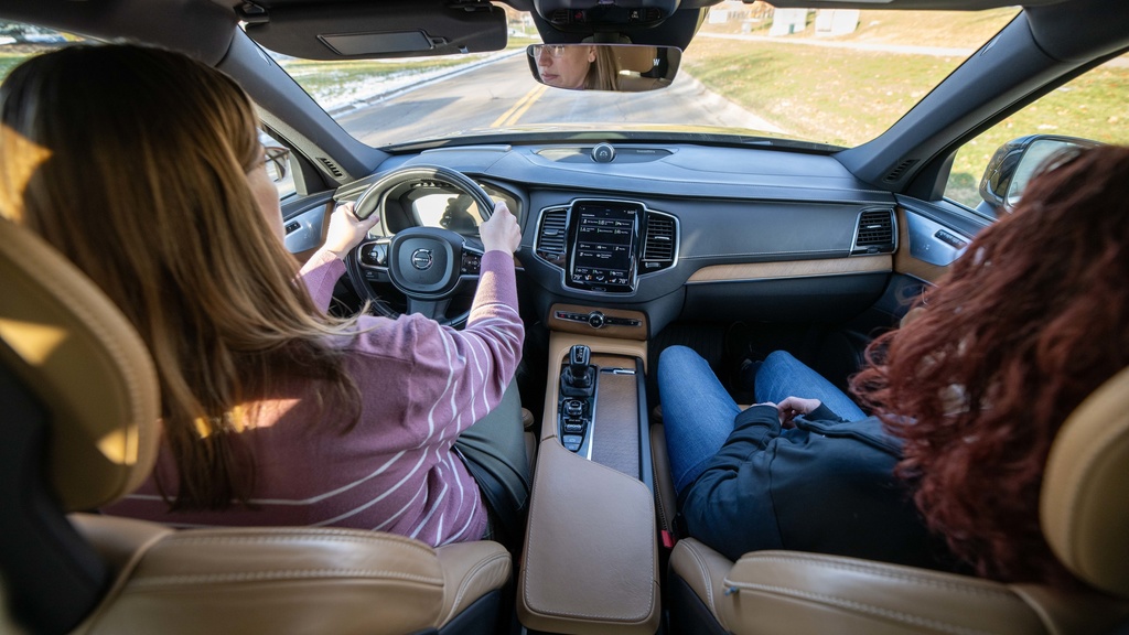 An aerial view of two women sitting in the front of a Volvo XC90 while using adaptive cruise control/