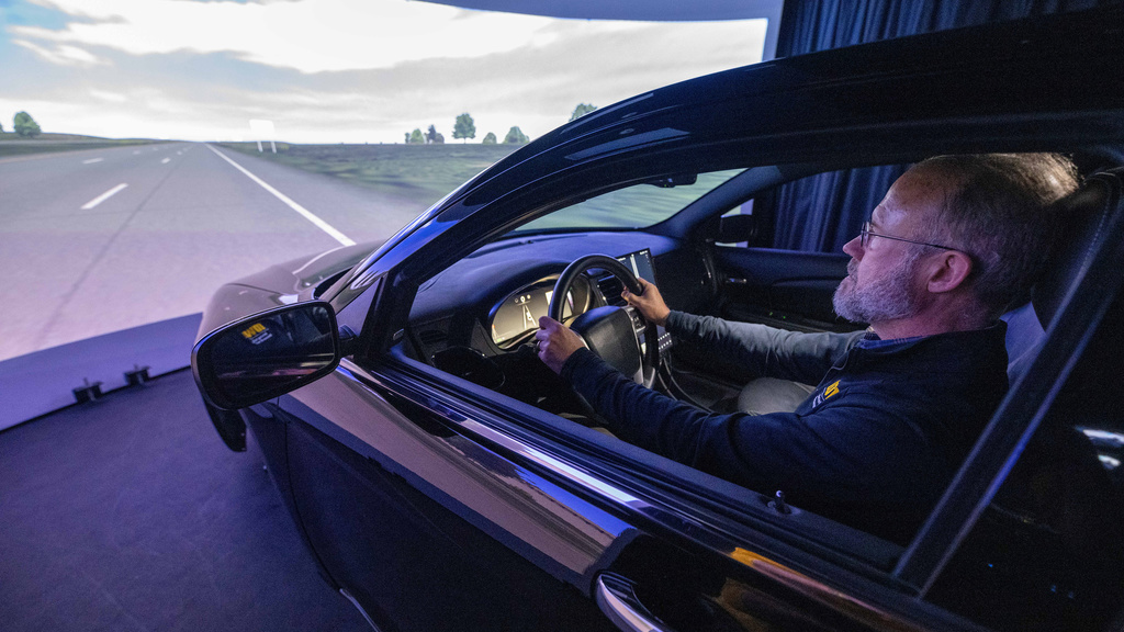 A man drives a car in a driving simulator. 